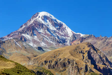 View of Mount Kazbek from Gergeti Trinity Church, Georgiaの写真素材