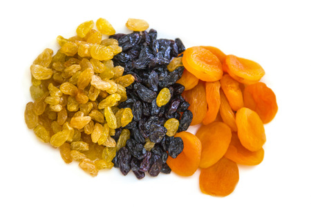raisins black and yellow dried apricots on white backgroundの写真素材