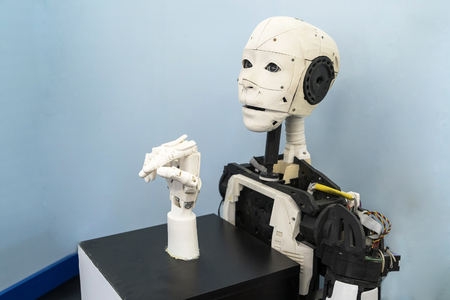 Chelyabinsk. Russia - February 24, 2019.Stand for the manufacture of robots, a Robot with a human face, a mechanical hand, a bionic hand. Exhibition on robotics - Robo Stars a Festival of robotsのeditorial素材