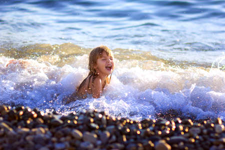 The little girl swims in the seaの写真素材