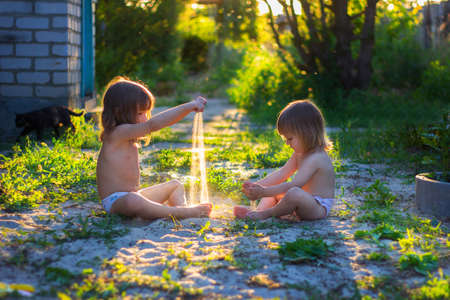 Girls play with sand in the yardの写真素材