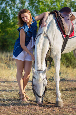 The girl in shorts embraces a horseの写真素材