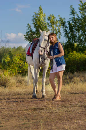 The girl in shorts embraces a horseの写真素材