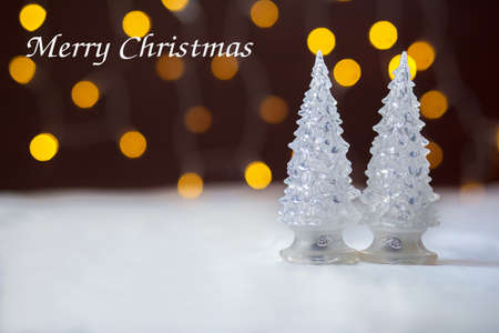 Two toy New Year trees against the background of fires. Inscription of the Merry Christmasの写真素材