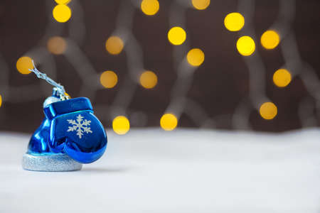 Christmas Christmas-tree decorations, cap and mitten against the background of yellow firesの写真素材