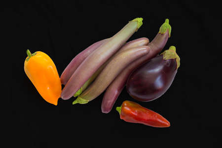 Different grades of Eggplants and pepper on a black background. Long eggplants. Vegetablesの写真素材