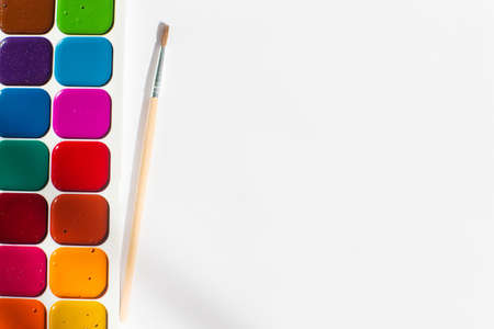 Multi-colored bright Watercolor paints with a brush. A frame from paints on a white background.の写真素材