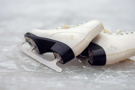 White ice skates for figure skating lie on an ice rinkの写真素材