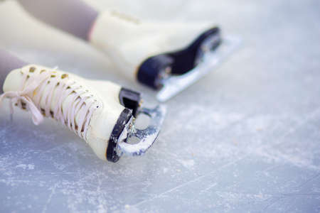 Children's white figure skates on an ice rink close-up. Figure skating - winter sportの写真素材