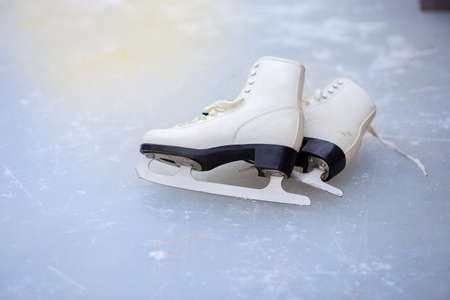 A pair of curly female skates lies on the ice at the rink.の写真素材