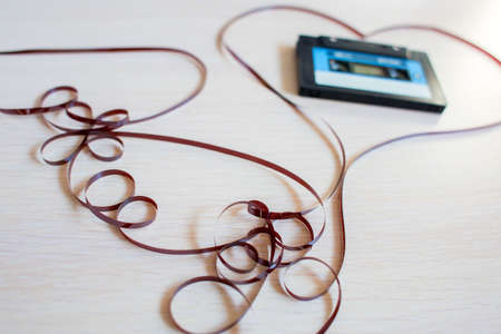 The recorder cartridge from the 90th lies in heart from a magnetic tape on a white background.の写真素材