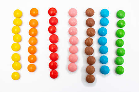 Multi-colored small jelly beans sweets are laid out in colors in straight lines.の写真素材