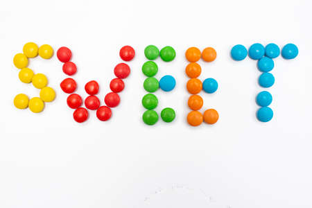 The inscription Sweet written in round small multi-colored sweets drageesの写真素材