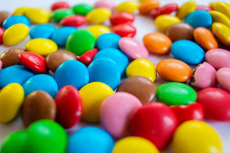 Many multi-colored small round sweets are scattered on the tableの写真素材