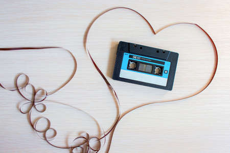 The recorder cartridge from the 90th lies in heart from a magnetic tape on a white background.の写真素材