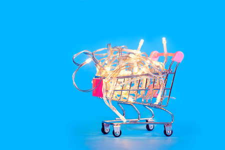 A small shopping cart full of Christmas lights. Preparing for Christmasの写真素材