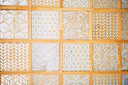 Wooden background in the form of many squares with various sawn patternsの写真素材