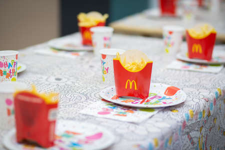 Table setting with fast food dishes. French fries in individual red boxesのeditorial素材
