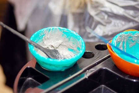 Hair dye prepared in a cup close-up on a table in a hairdressing salon