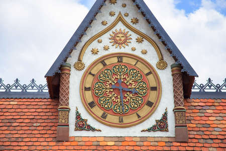 Symmetrical towers at the front entrance to the park, decorated with clocks. Russian style of architecture. Decorating with beautiful Russian ornamentの写真素材