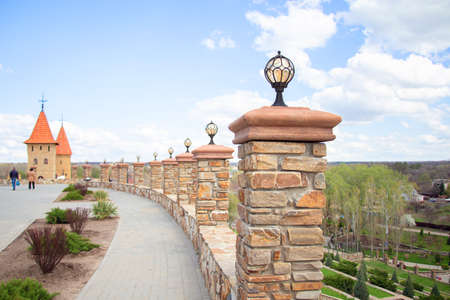 Street lighting. Stone fence with towers. Fence decorated with facing stone in the parkの写真素材
