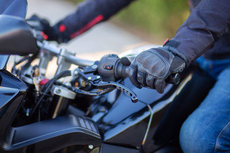 Biker's hand in motorcycle gloves close-up. Motorcyclist holding the handlebars of a motorcycleの写真素材