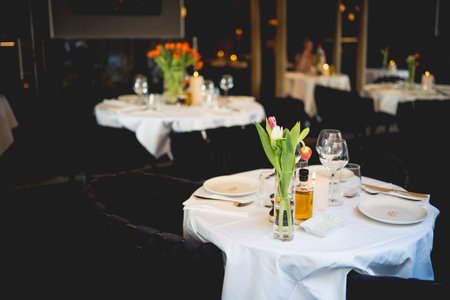 Elegant Table Setting in a Fine Dining Indoor Restaurant with Fresh Tulipsの写真素材