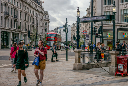Bustling Oxford Circus Station with Iconic Red Double Decker Bus in Central London Capturing Urban...