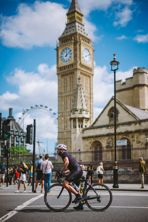Cyclist in Motion Near Iconic London Landmark on a Bright Sunny Day with Blue Skies and Historical...