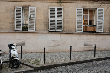 Charming Urban Scene with Vintage Scooter by Historic European Stone Building Facadeの写真素材