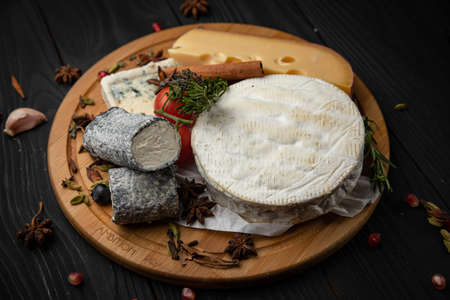 assorted cheeses on a wooden board