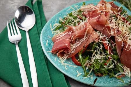 Jamon, parma, herbs, Parmesan on a plate as a snackの写真素材