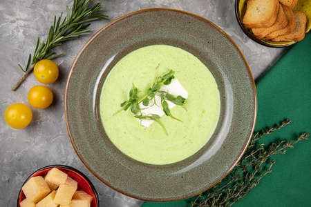 Homemade soup on a gray concrete background with croutons, tomatoes and parmesanの写真素材