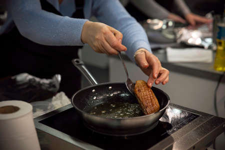 Frying meat on frying pan in restaurants on kitchensの写真素材