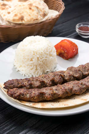 meat on pita bread with rise on a black wooden backgroundの写真素材