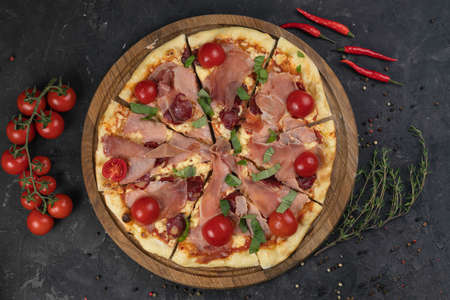 Italian pizza with tomatoes on a black backgroundの写真素材