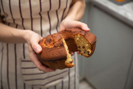 Baked homemade cupcake in the hands of a womanの写真素材