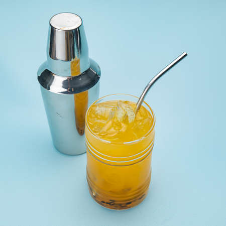 passion fruit lemonade in a bar glass with ice on a blue backgroundの写真素材