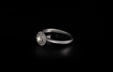 Gold ring with a diamond gemstone isolated on a black backgroundの写真素材