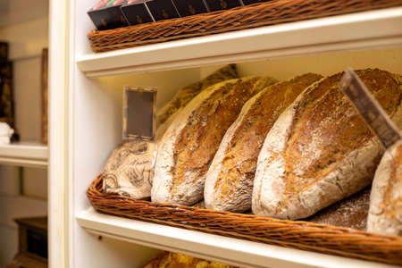 Bread in a bread bench, laid out on the shelves of a shop windowの写真素材
