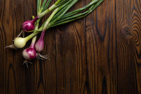 Fresh farm onions on a brown wooden backgroundの写真素材