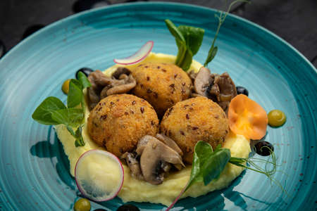 round meatballs with mashed potatoes and grilled vegetables. In the top restaurant