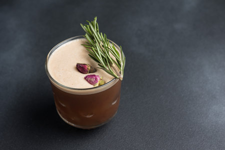 A glass of chocolate smoothie with rosemary on a black backgroundの写真素材