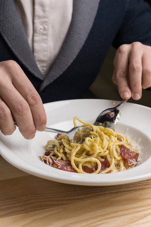 Spaghetti carbonara with bacon and parmesan on white plateの写真素材
