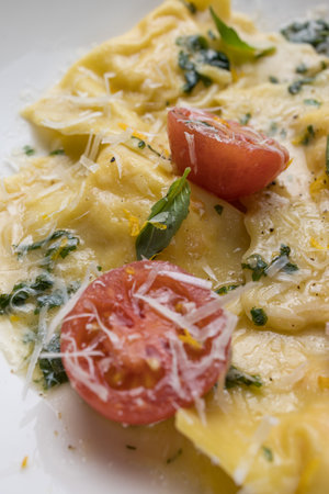 Ravioli pasta with tomato and basil on white plate.の写真素材