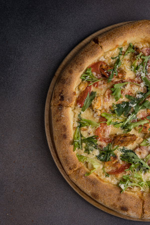 Pizza with bacon, cheese and arugula on dark backgroundの写真素材