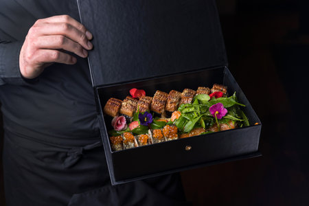 Sushi in a box in the hands of a waiter. Restaurant