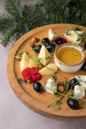 Cheese platter with olives, nuts and honey on wooden plateの写真素材
