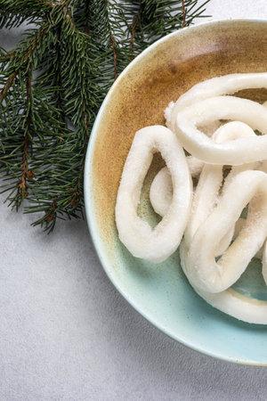 Frozen squid rings in a bowl on the background of fir branchesの写真素材