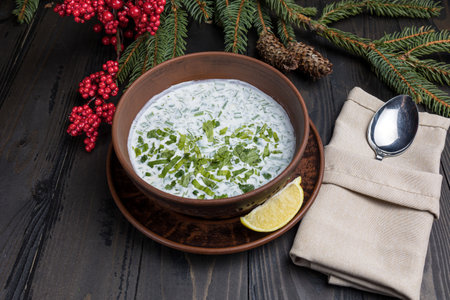 Traditional cold tzatziki soup with yogurt and herbs on wooden backgroundの写真素材